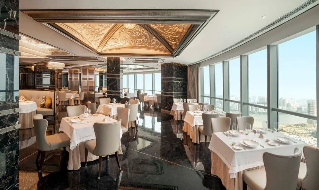 Restaurant tables with layered tablecloths beside dining chairs