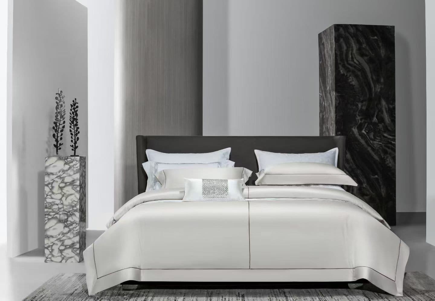 Complete white hotel bedding collection in a neutral guestroom setting