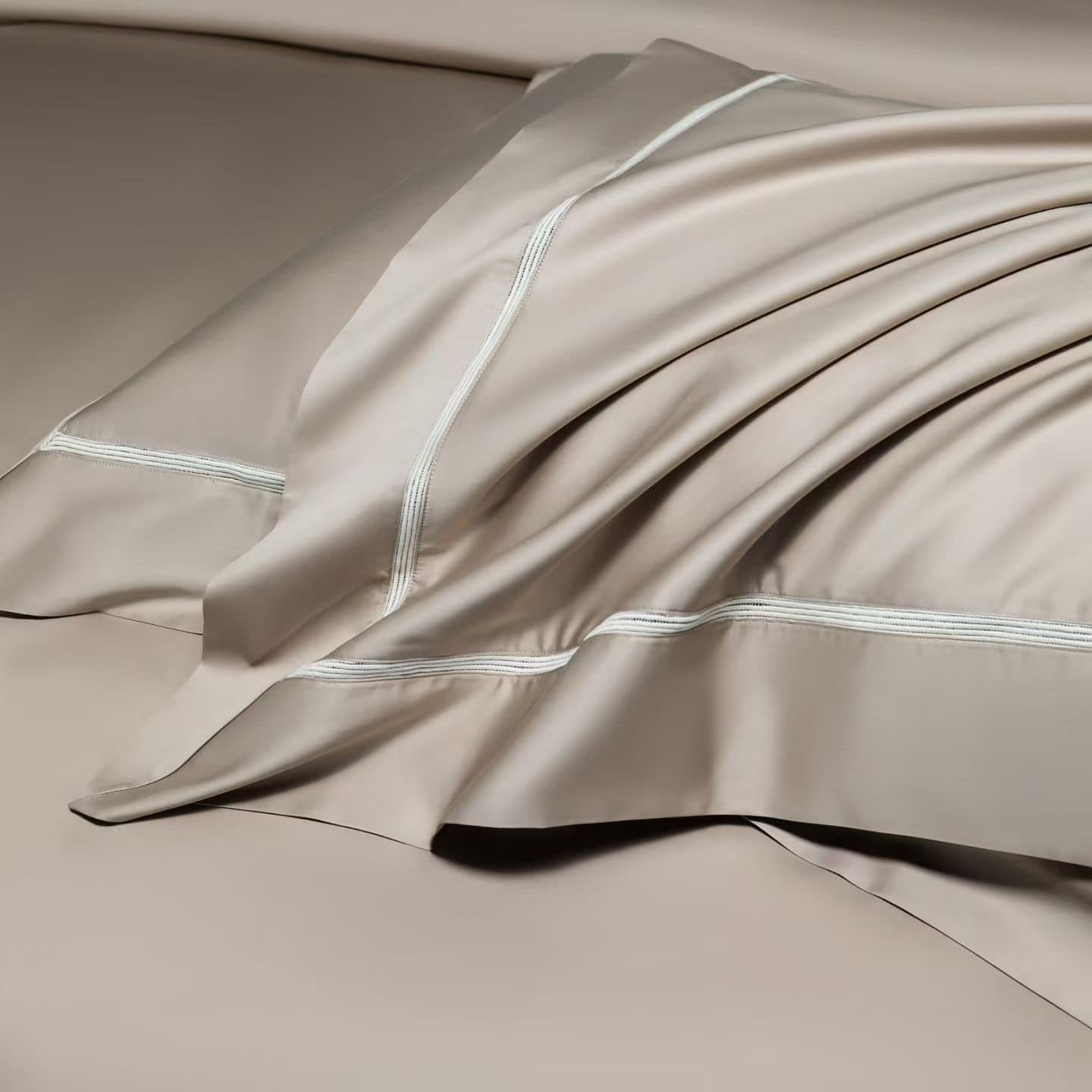 Neutral hotel bed linen showing fabric finish and edge detailing