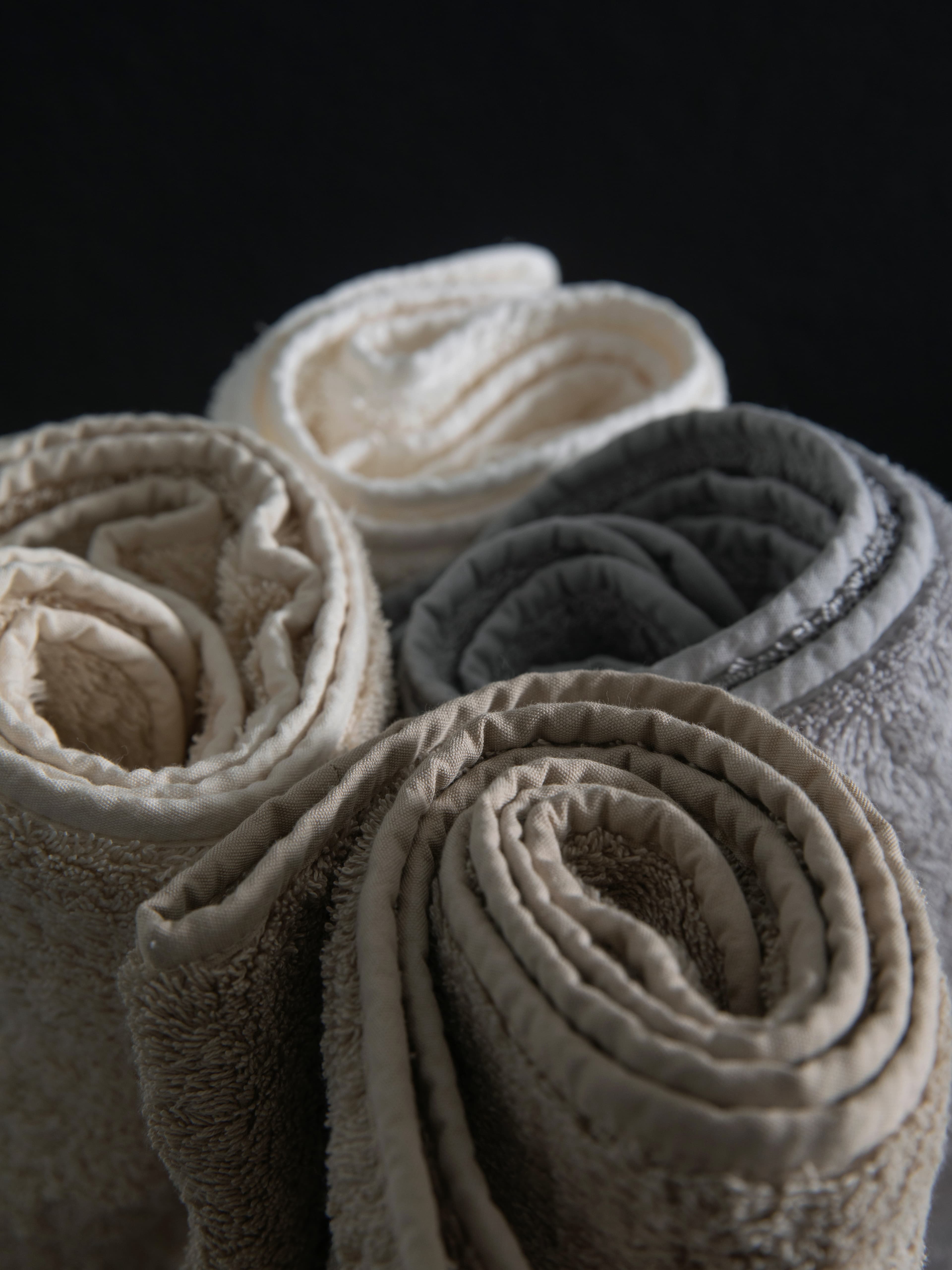 Rolled neutral hotel towels grouped as a hospitality collection